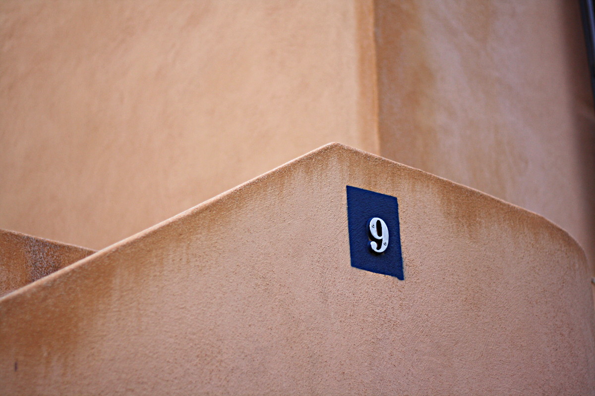Plaque de rue en haut d'un escalier : « 9 »